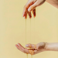 Sugar Paste Dripping off a Hand on a Yellow Background